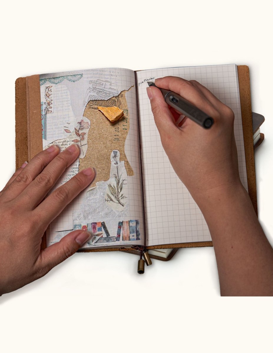 Person writing in a handmade leather travel journal with a grid refill while using the notebook for collage scrapbooking and journaling.