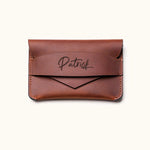 Handcrafted brown leather wallet with personalized name engraving, minimalist slim card holder design with envelope-style flap for everyday carry.