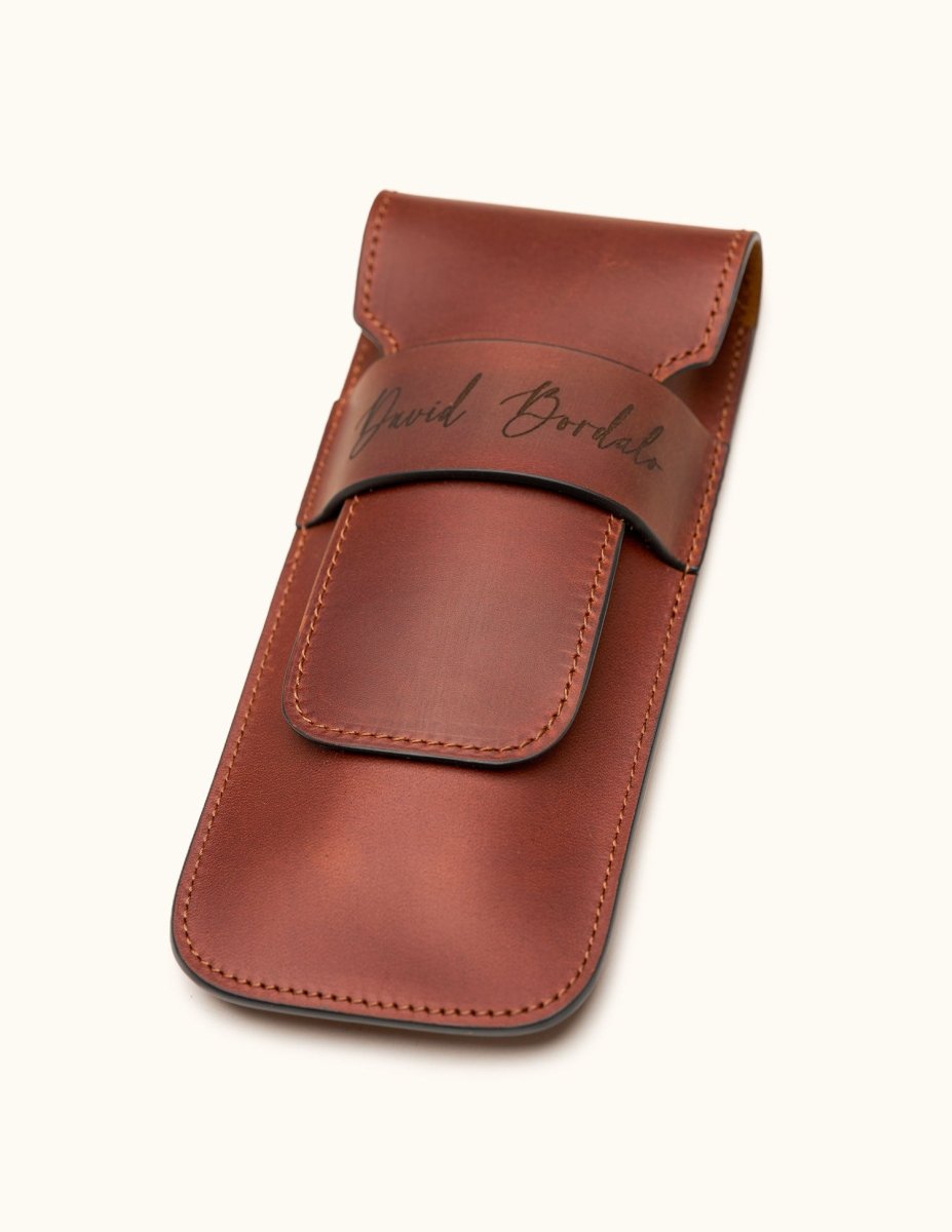 Angled view of a chestnut brown double cigar case made from full-grain leather, engraved with the name "David Bordalo", highlighting stitching and craftsmanship