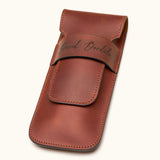 Angled view of a chestnut brown double cigar case made from full-grain leather, engraved with the name "David Bordalo", highlighting stitching and craftsmanship