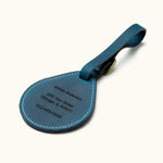 Back side of blue leather luggage tag with custom engraved name, address, and phone number