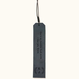 Blue leather bookmark engraved with the message "You're my favorite book worm. I love you, Kevin" and personalized initials "K | J" inside a laurel wreath design