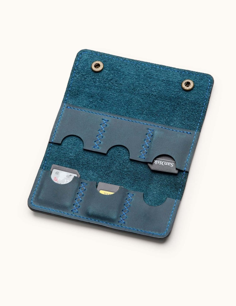 Open view of blue leather SD card holder with six hand-stitched slots, designed for storing memory cards or Switch game cartridges