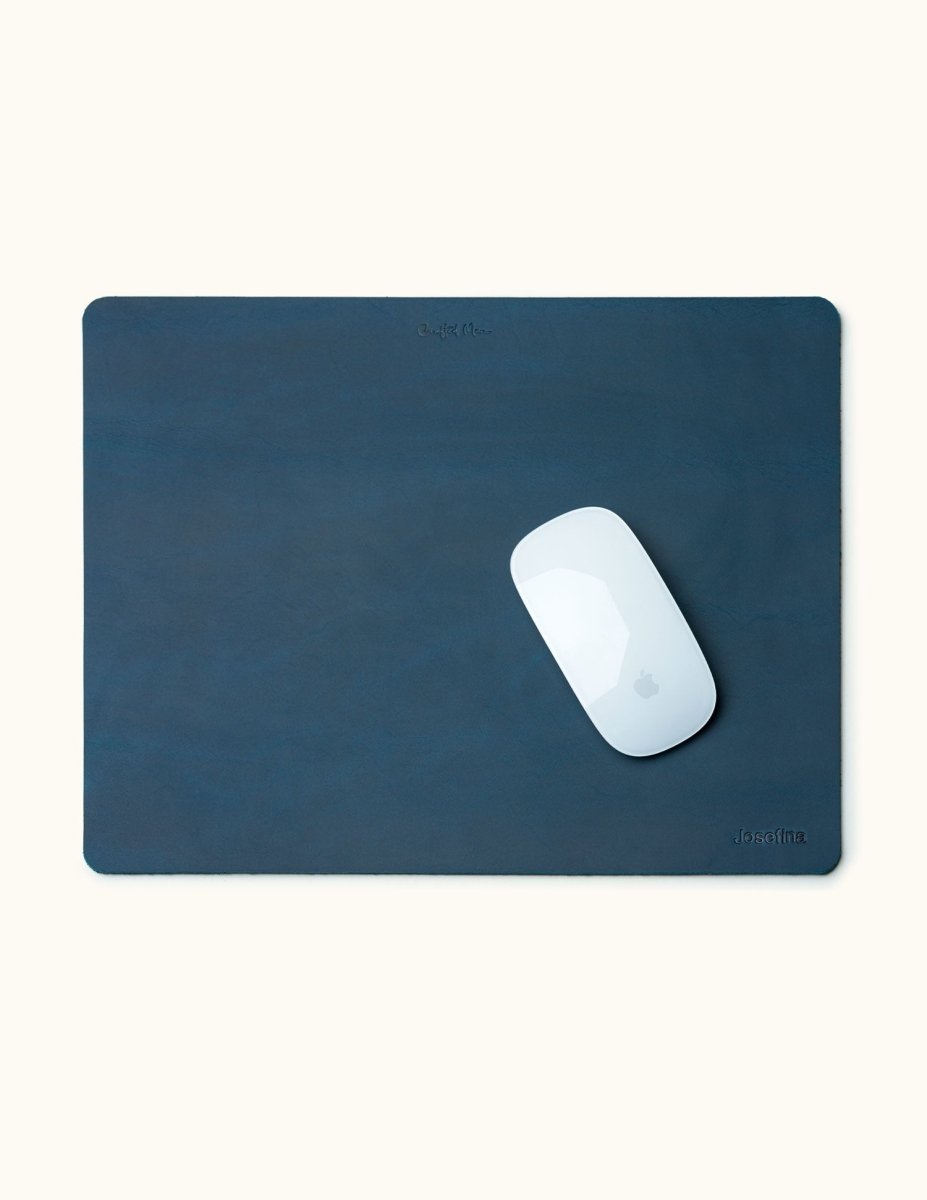 Top-down view of blue personalized leather mouse pad with engraved name and Apple Magic Mouse