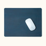 Top-down view of blue personalized leather mouse pad with engraved name and Apple Magic Mouse