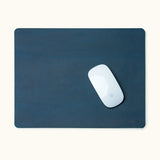 Top-down view of blue personalized leather mouse pad with engraved name and Apple Magic Mouse