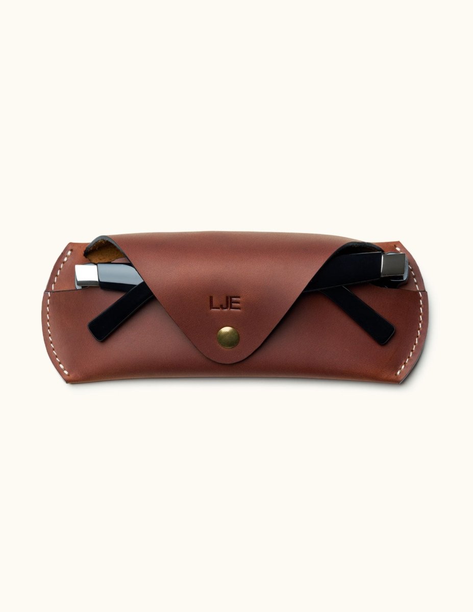 Personalized brown Crazy Horse leather glasses case with sunglasses partially inserted and snap button closure