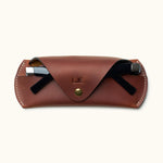 Personalized brown Crazy Horse leather glasses case with sunglasses partially inserted and snap button closure
