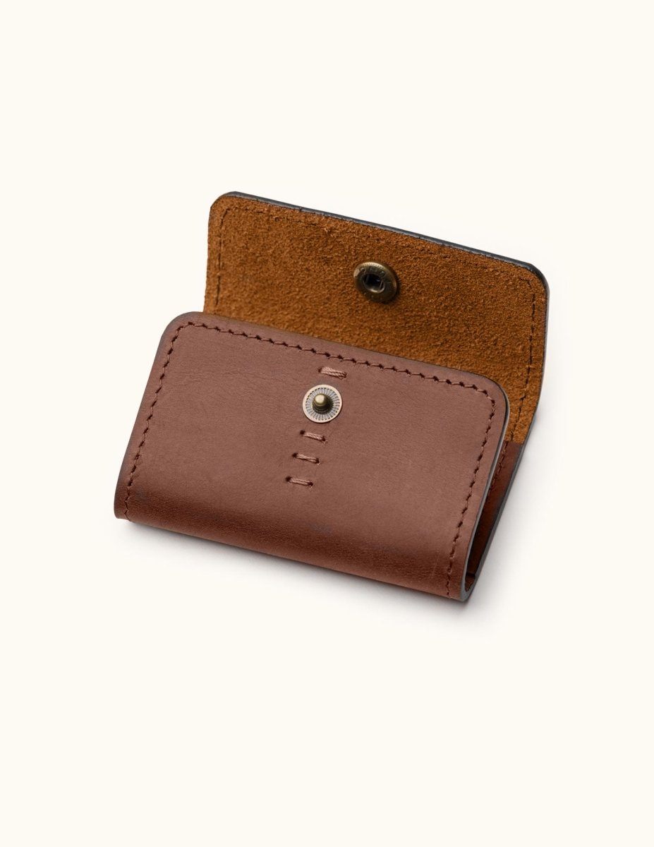 Angled view of brown leather SD card holder showing snap closure and flap construction with suede interior