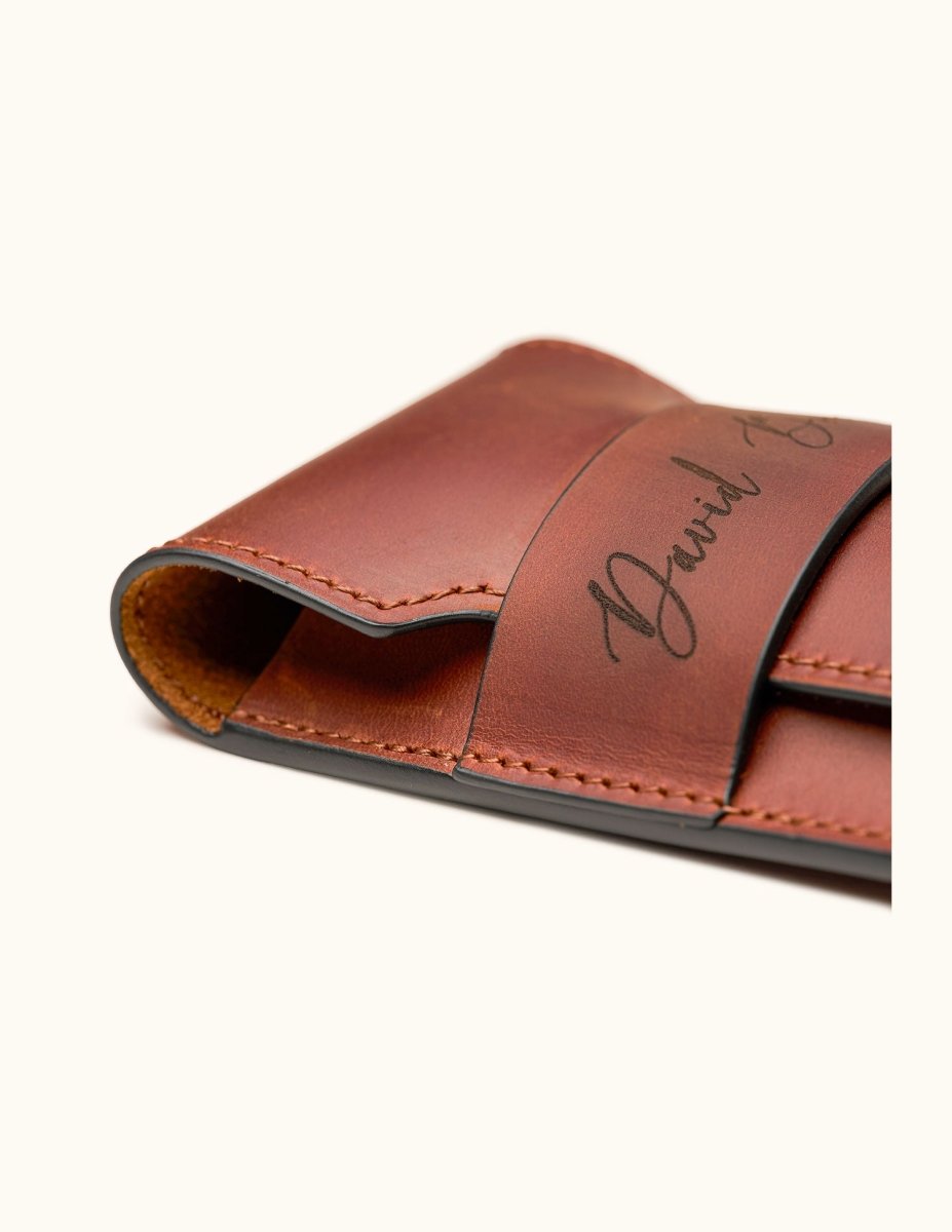 Close-up of a personalized full-grain leather cigar case showing edge finishing, hand-stitching, and engraved name "David Bordalo"