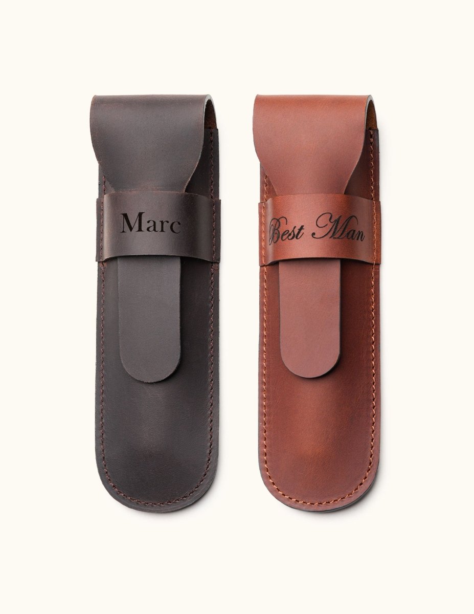 Two personalized leather single cigar cases in dark brown and tan, engraved with names and titles such as "Marc" and "Best Man", featuring a flap closure and stitched edges