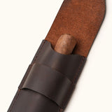 Close-up of a dark brown full-grain leather cigar case with flap open and cigar partially inserted, highlighting the craftsmanship and suede-textured inner lining