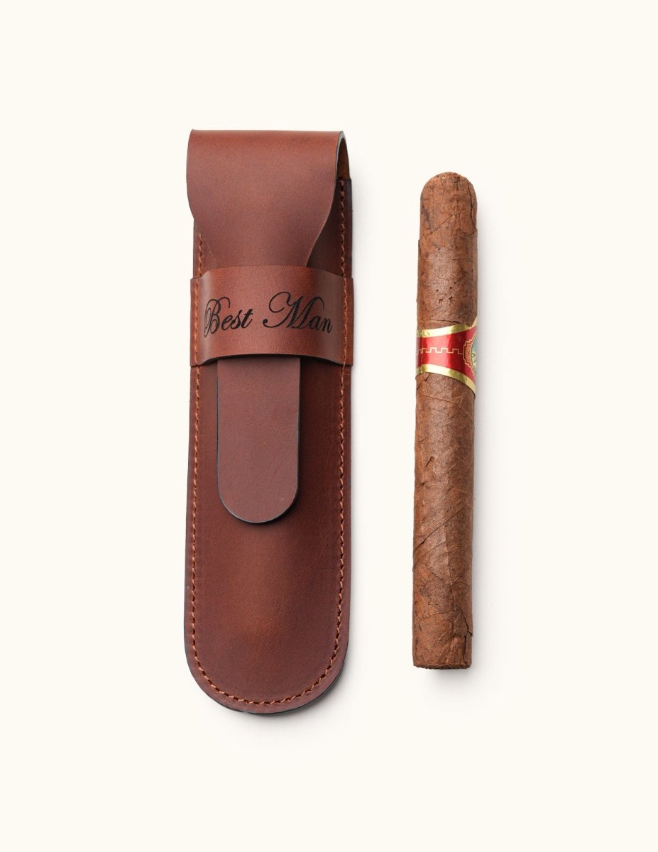 Brown full-grain leather single cigar case engraved with "Best Man", displayed next to a single cigar. A personalized travel accessory for cigar lovers or groomsmen gifts