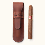 Brown full-grain leather single cigar case engraved with "Best Man", displayed next to a single cigar. A personalized travel accessory for cigar lovers or groomsmen gifts