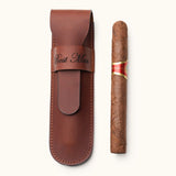 Brown full-grain leather single cigar case engraved with "Best Man", displayed next to a single cigar. A personalized travel accessory for cigar lovers or groomsmen gifts