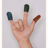 Hand showing three fingers wearing full-grain leather thimbles in blue, green, and brown, ideal for sewing or crafting.