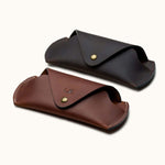 Two handcrafted Crazy Horse leather sunglasses cases in brown and dark brown, with snap buttons and personalized initials