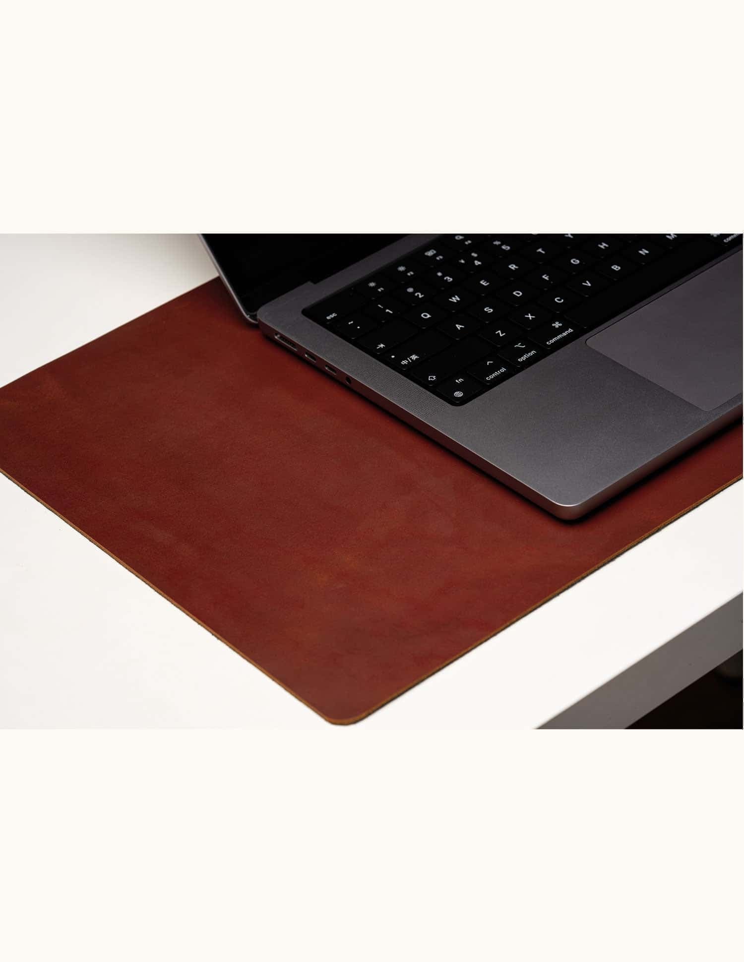 Large personalized leather desk mat used under a laptop, top-grain surface for workspace organization