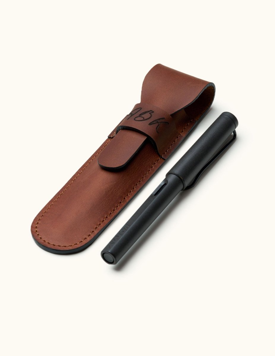 Custom leather fountain pen case with flap closure, shown alongside a matte black fountain pen. Ideal for gifting or everyday protection