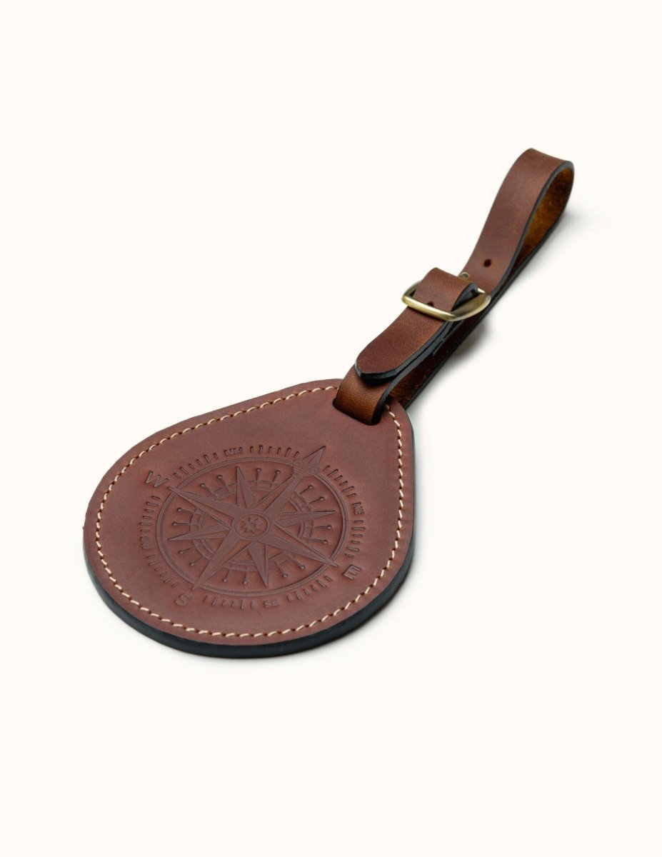 Full-grain leather round luggage tag with compass design and brass buckle strap