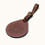Full-grain leather round luggage tag with compass design and brass buckle strap