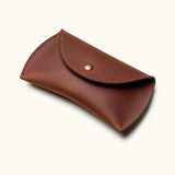 Brown leather travel case for Apple Magic Mouse with snap button closure, angled view