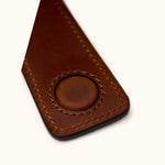 Close-up detail of magnetic clasp and hand-stitched brown leather money clip – durable craftsmanship and premium finish