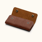 Back view of brown leather SD card holder with snap button closure and hand-stitched detailing