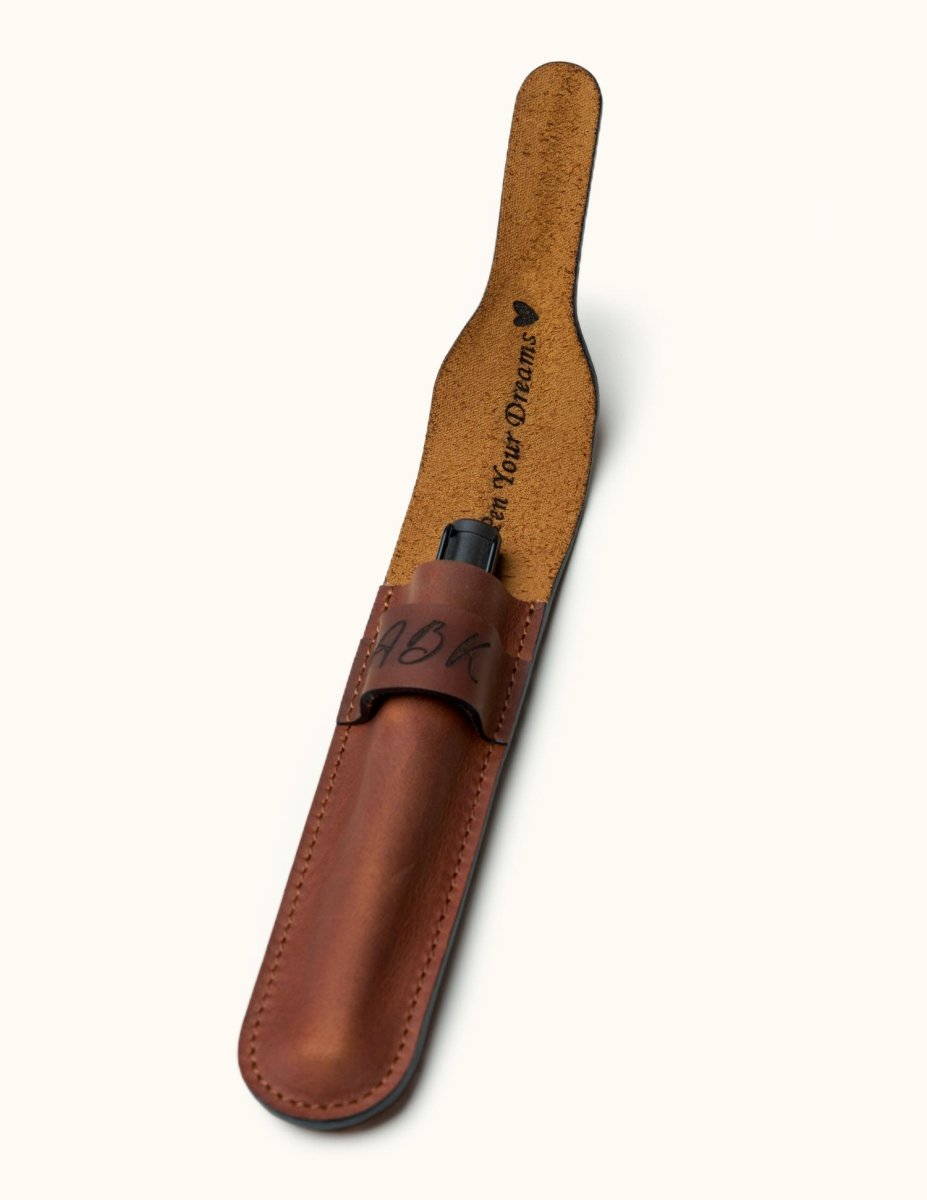 Open full-grain leather pen case with flap lifted to reveal custom inner engraving, showcasing a sleek fountain pen inserted inside