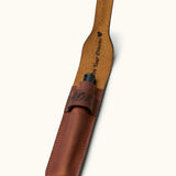 Open full-grain leather pen case with flap lifted to reveal custom inner engraving, showcasing a sleek fountain pen inserted inside