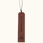 Brown leather bookmark engraved with "To many more chapters together" and personalized initials and date "A&S 07.12.08", shown on a plain background