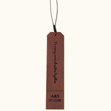 Brown leather bookmark engraved with "To many more chapters together" and personalized initials and date "A&S 07.12.08", shown on a plain background