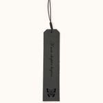 Five personalized leather bookmarks in different colors, each engraved with custom quotes, initials, or dates, with decorative tassel cords on top.