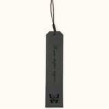 Five personalized leather bookmarks in different colors, each engraved with custom quotes, initials, or dates, with decorative tassel cords on top.