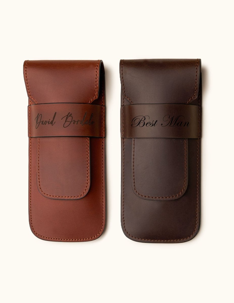 Two personalized full-grain leather double cigar cases in chestnut and dark brown, engraved with names and titles like "David Bordalo" and "Best Man" — a refined gift for groomsmen or cigar aficionados