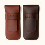 Two personalized full-grain leather double cigar cases in chestnut and dark brown, engraved with names and titles like "David Bordalo" and "Best Man" — a refined gift for groomsmen or cigar aficionados