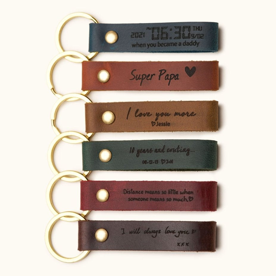 Handcrafted leather keychains in multiple colors with gold rings, engraved with custom personalized texts like dates, names, quotes, and “Super Papa,” perfect for Father’s Day, anniversaries, or everyday gifts.