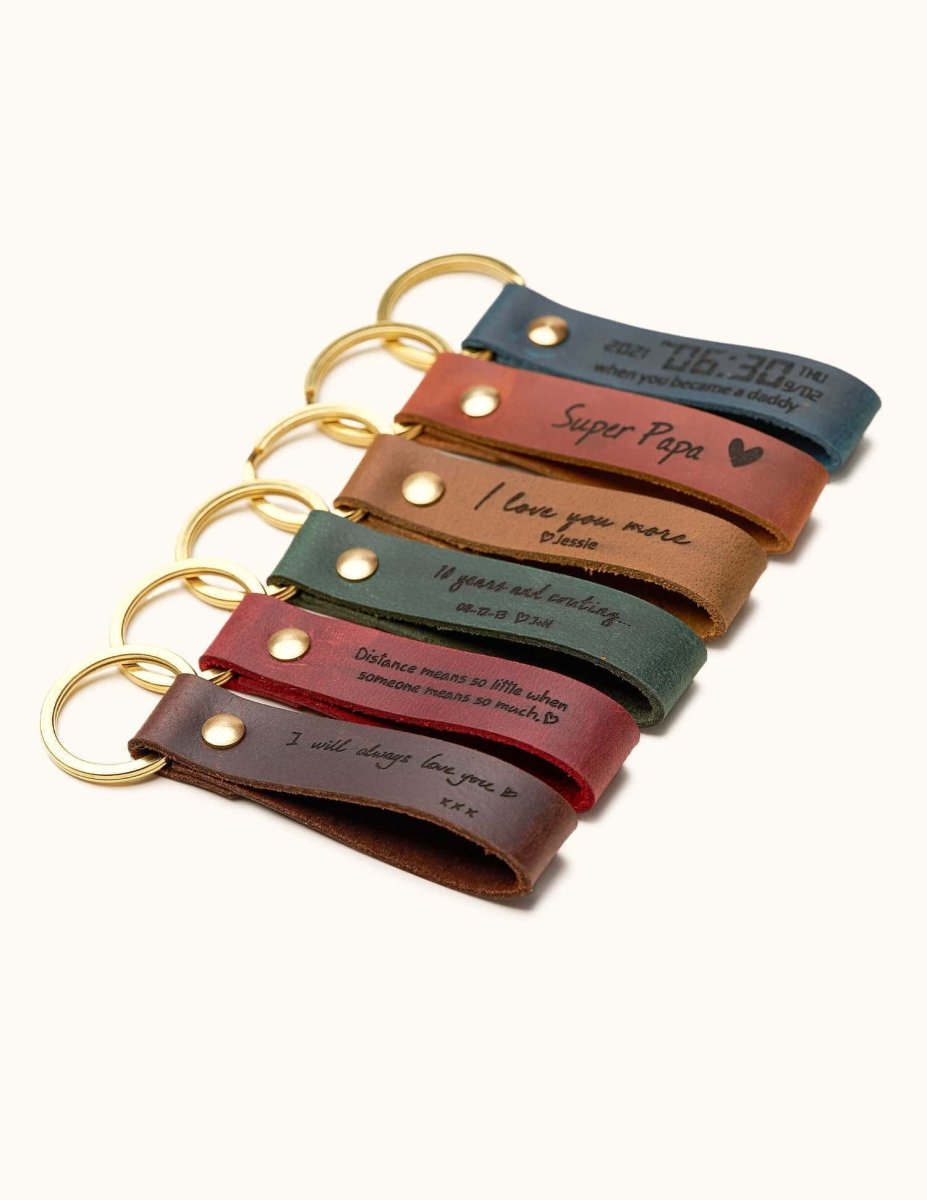 Handmade leather keychains in assorted colors with gold rings, engraved with custom messages, dates, and quotes, perfect for personalized gifts, anniversaries, and Father’s Day.