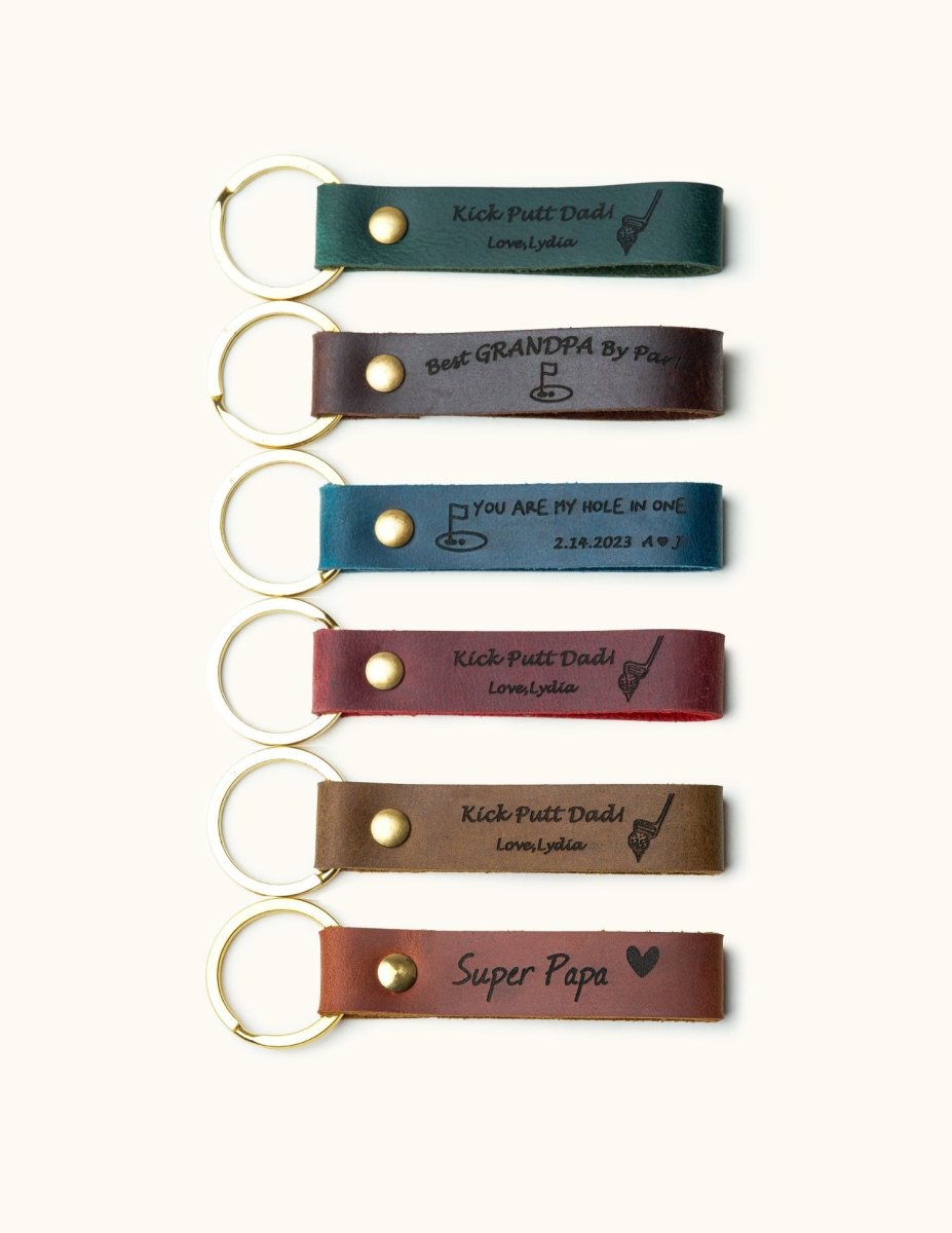 Handmade leather keychains with gold rings, engraved with golf-themed messages like “Kick Putt Dad” and “Best Grandpa,” perfect personalized gifts for golf lovers, dads, and grandpas.

