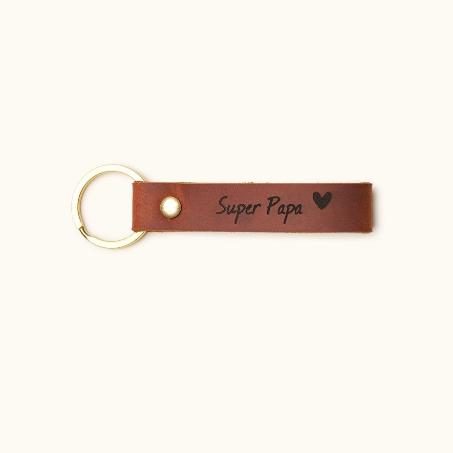 Handmade brown leather keychain with gold keyring, engraved with “Super Papa” and heart, perfect personalized gift for dad on Father’s Day or birthday.