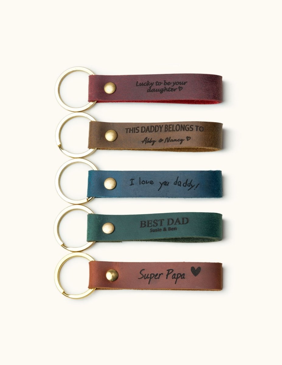 Five handmade leather keychains in different colors with gold keyrings, engraved with Father’s Day messages like “Super Papa” and “Best Dad,” perfect personalized gifts for dad.
