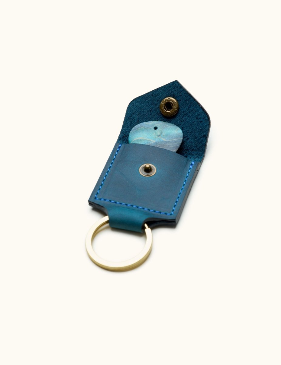 Open view of blue square leather guitar pick holder keychain with visible pick and snap closure