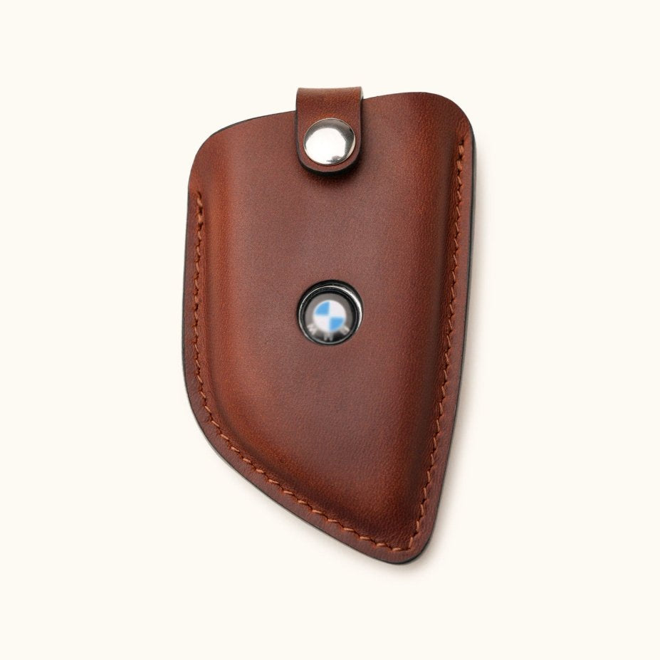 Front view of handcrafted brown leather key fob cover for BMW G Series smart key with logo window and snap closure
