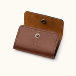Angled view of brown leather SD card holder showing snap closure and flap construction with suede interior