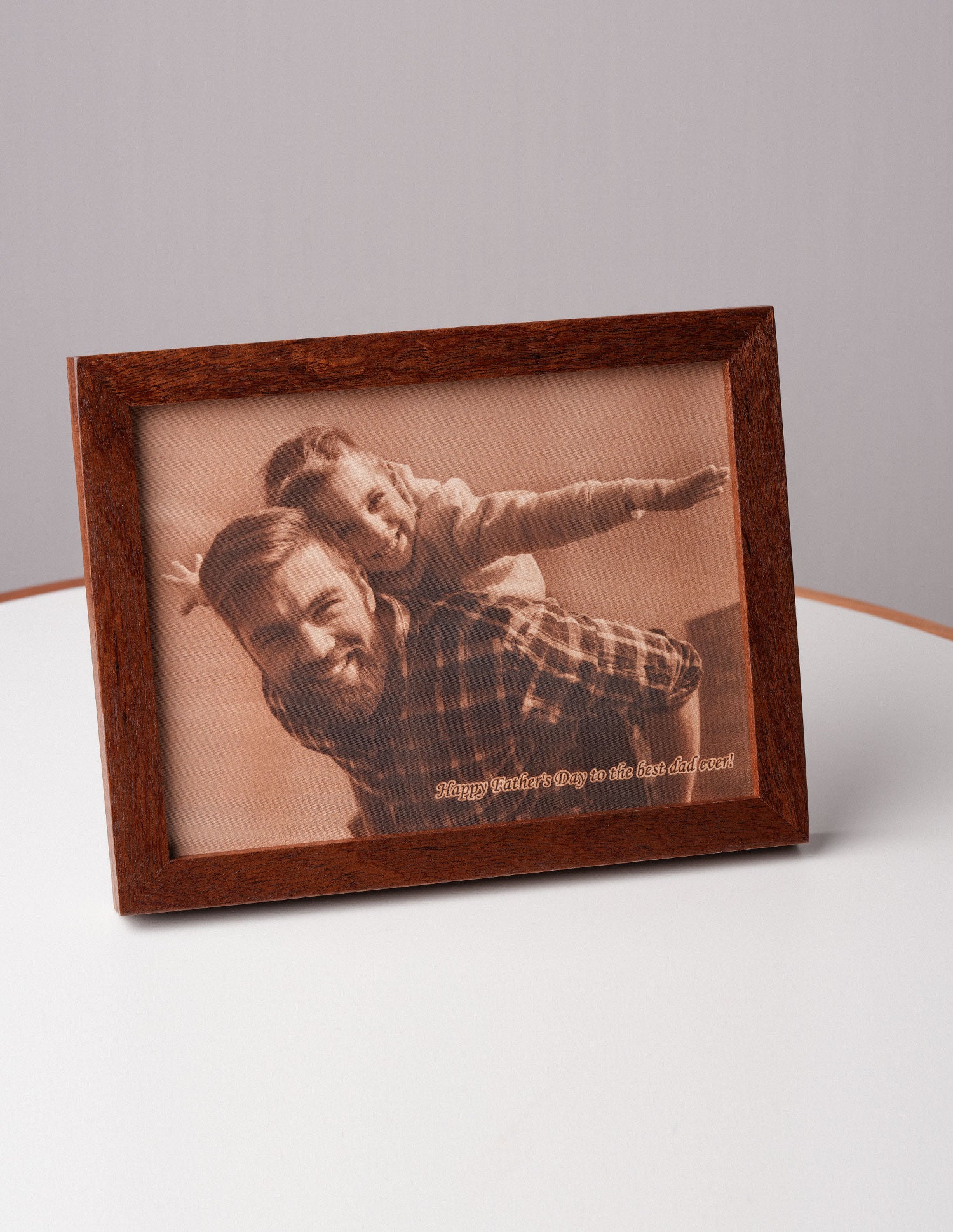 Angled view of a personalized leather photo frame with a father and daughter smiling together, engraved with the message “Happy Father’s Day to the best dad ever” — a unique handcrafted gift