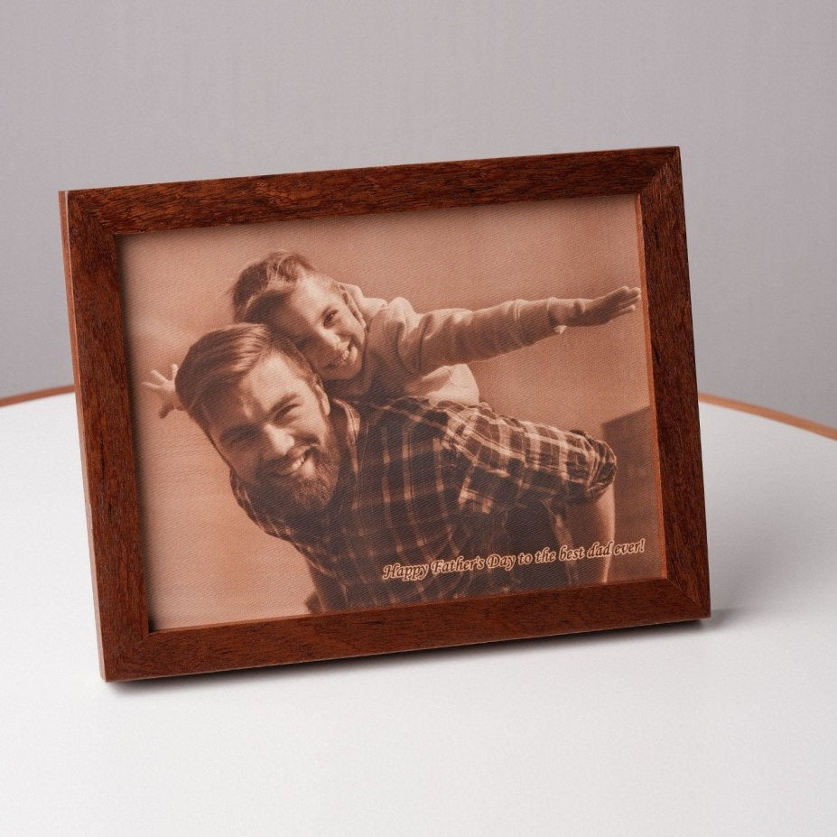 Angled view of a personalized leather photo frame with a father and daughter smiling together, engraved with the message “Happy Father’s Day to the best dad ever” — a unique handcrafted gift