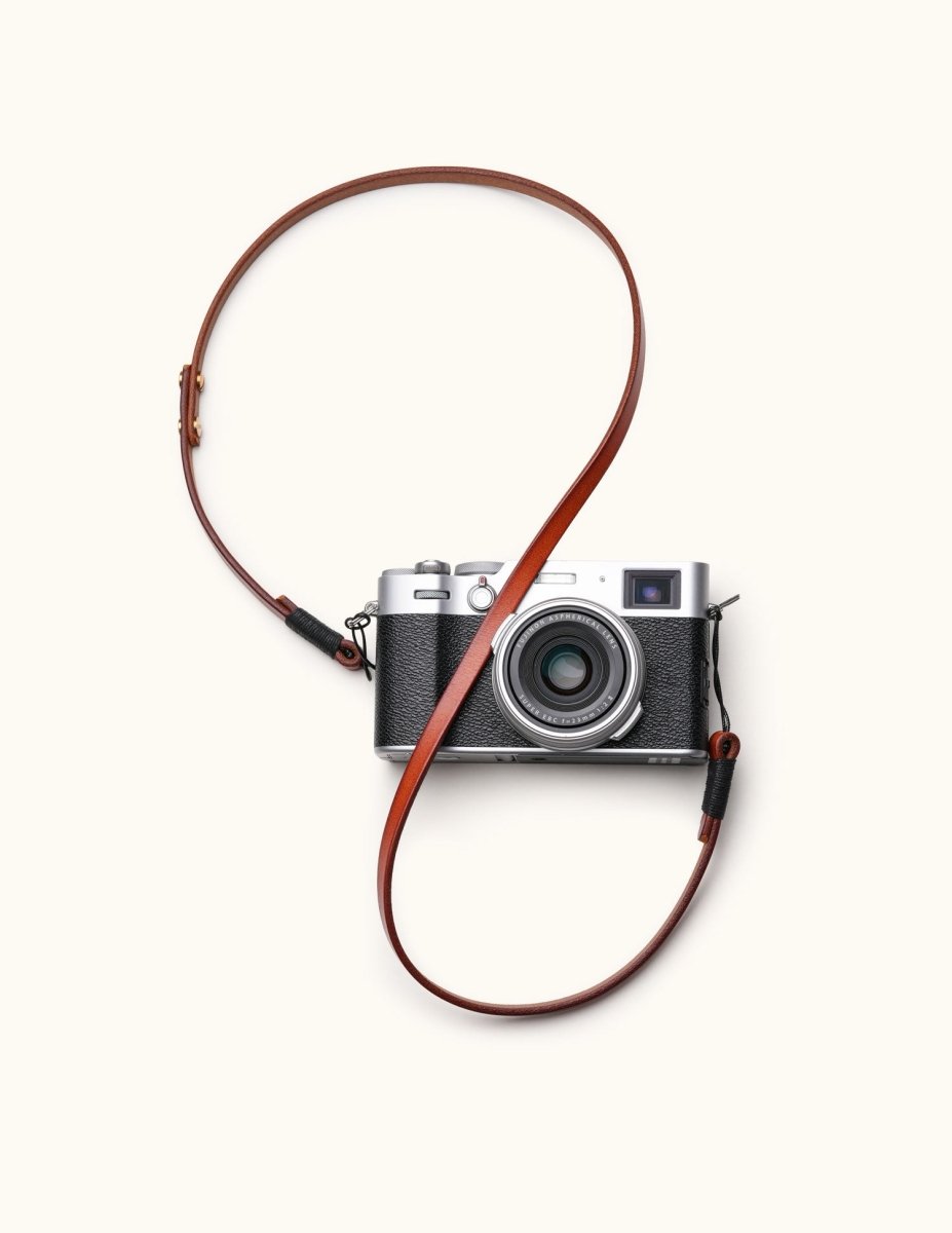 Full-grain handcrafted leather camera strap attached to a vintage-style mirrorless camera, styled in loop