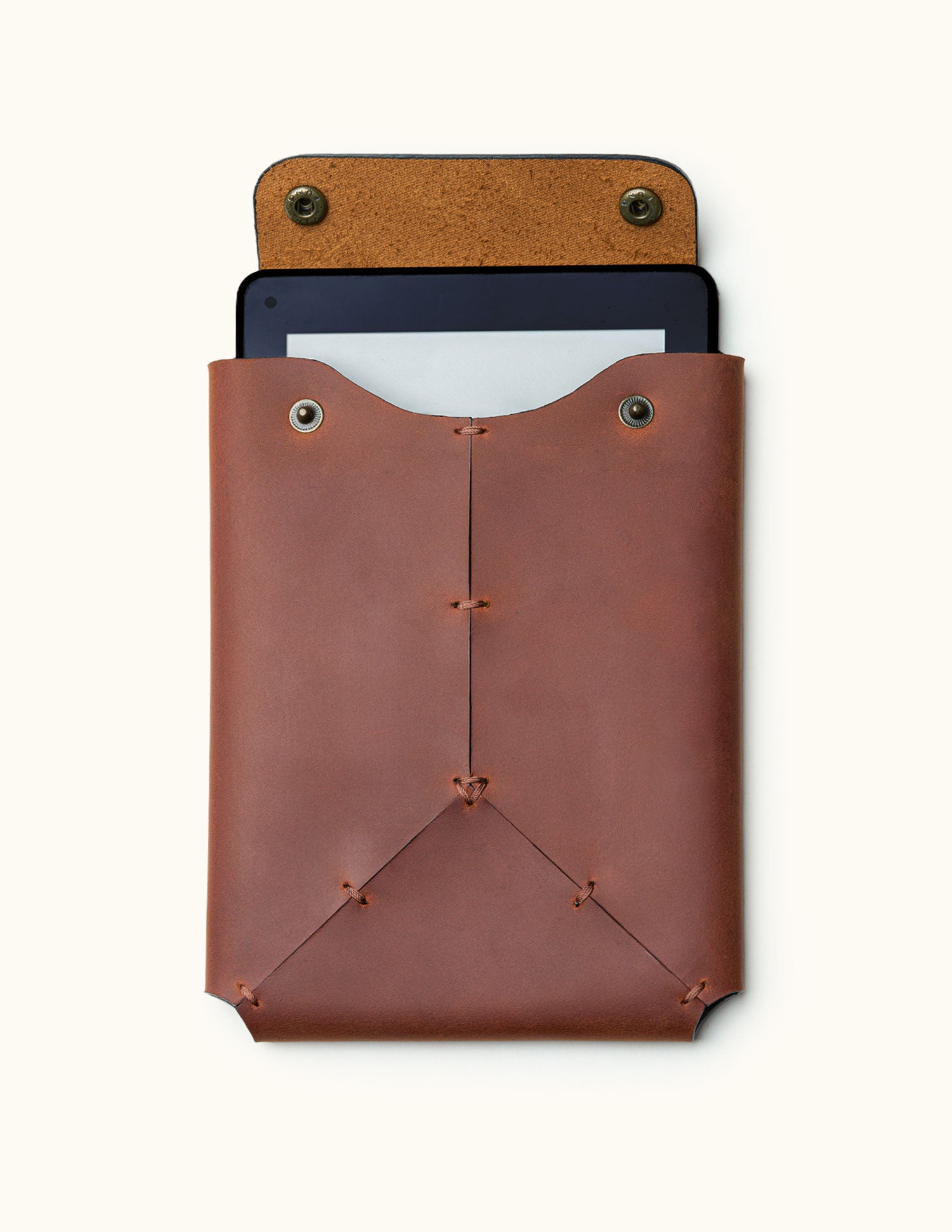 Front view of a handcrafted leather Kindle sleeve with snap button closure, shown with a Kindle device partially inserted inside
