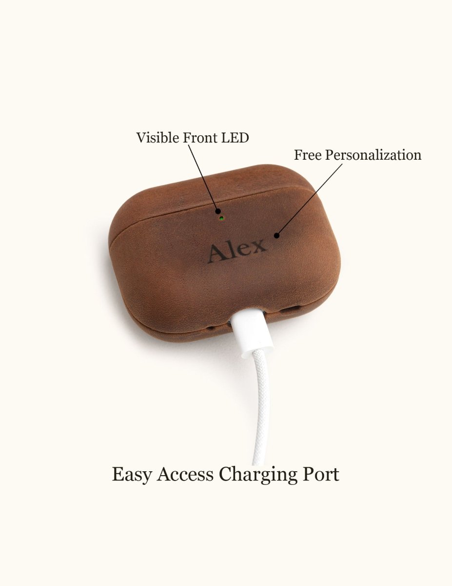 Bottom view of a personalized leather AirPods case plugged into a white charging cable. Demonstrates easy access to the charging port without removing the cover.