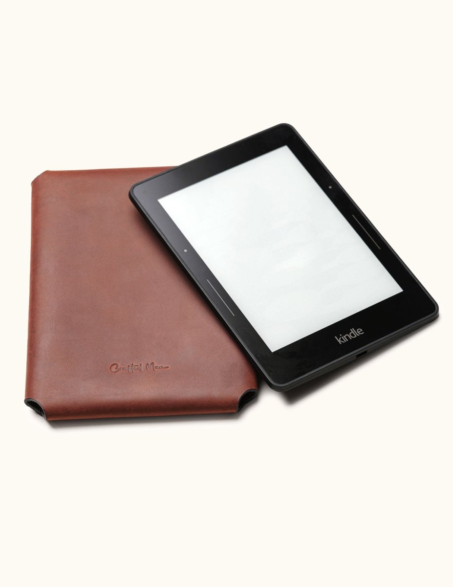 Handcrafted leather Kindle case in brown, designed for Kindle Paperwhite, Oasis, and Scribe models. Shown with a Kindle device partially inserted